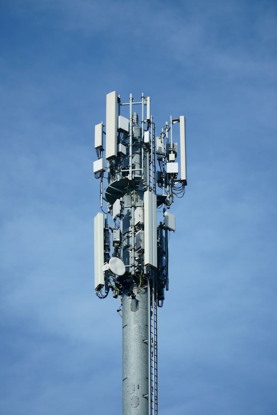 Telecommunication mast with cellular antennas against a blue sky