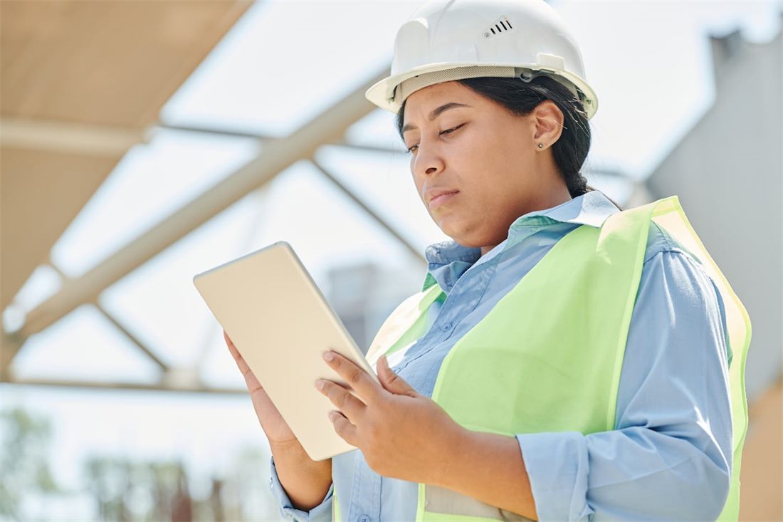 Field engineer using a tablet during an outdoor infrastructure inspection