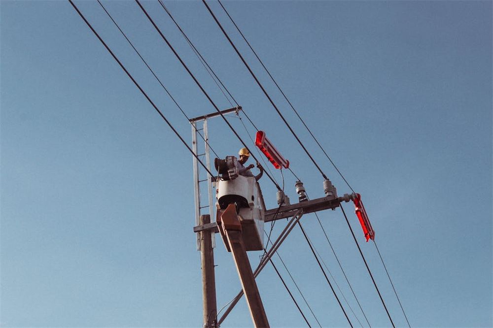 Electric utility worker repairing overhead power lines