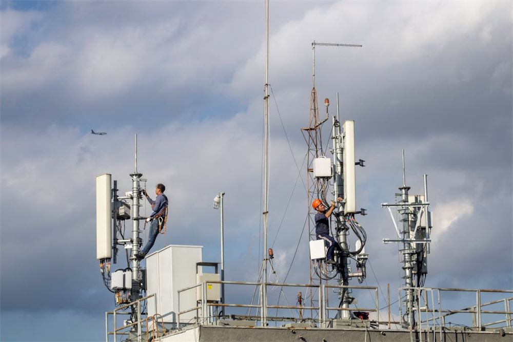 Technicians working on mobile communication tower infrastructure