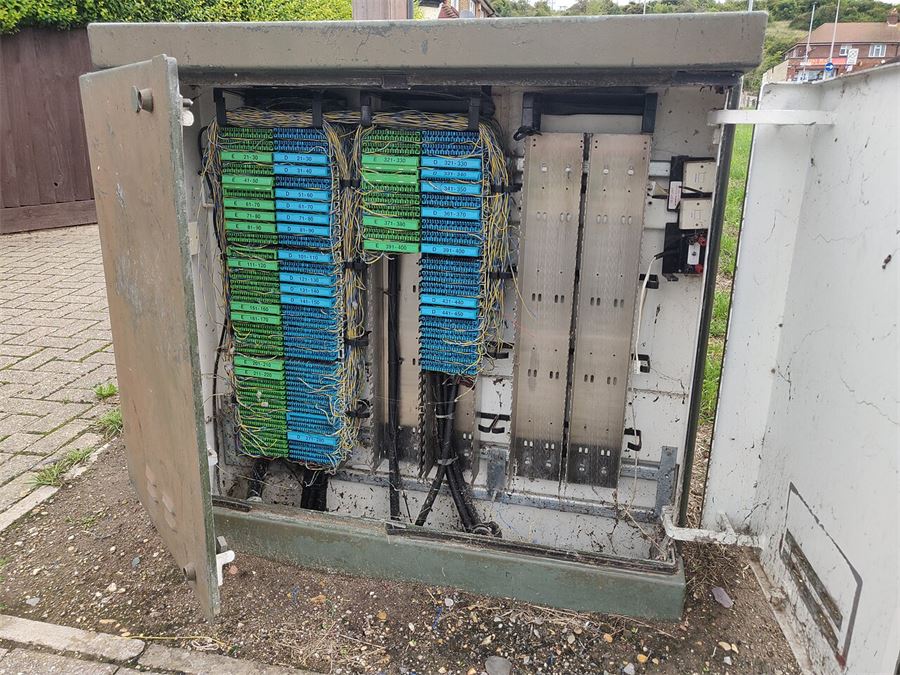Open telecommunications street cabinet showing internal wiring